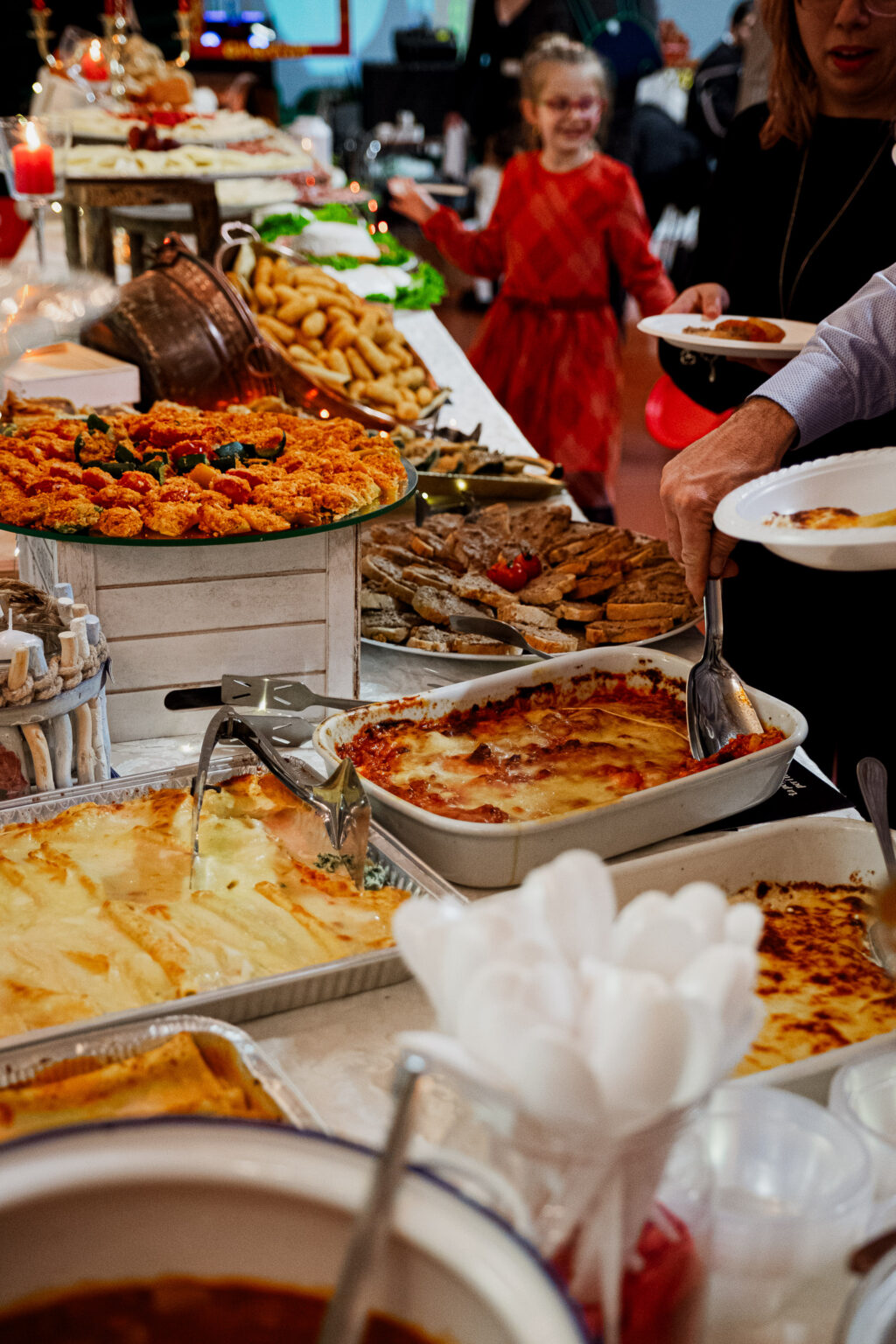 Buffet di un catering Voglia D Buono: teglie di lasagne e parmigiana e ospiti che si servono